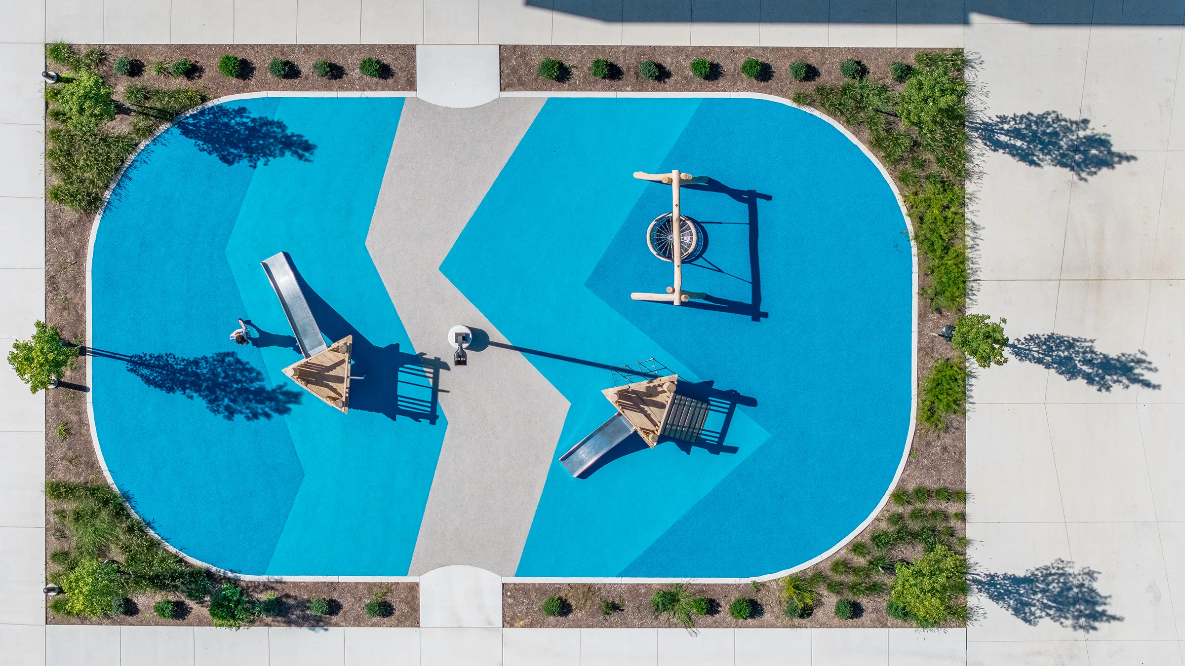 Small playground with bright blue surfacing.