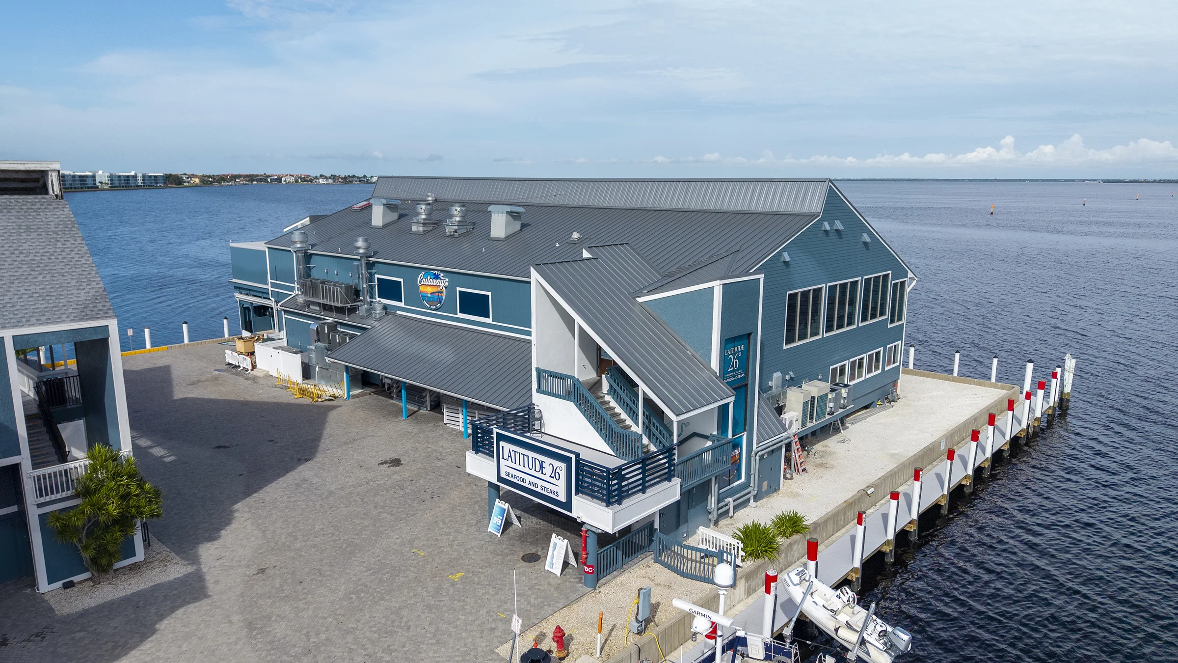 Teal building on the Charlotte Harbor housing two restaurants—Castaways on the open-air first floor and Latitude 26 on the more upscale second level.