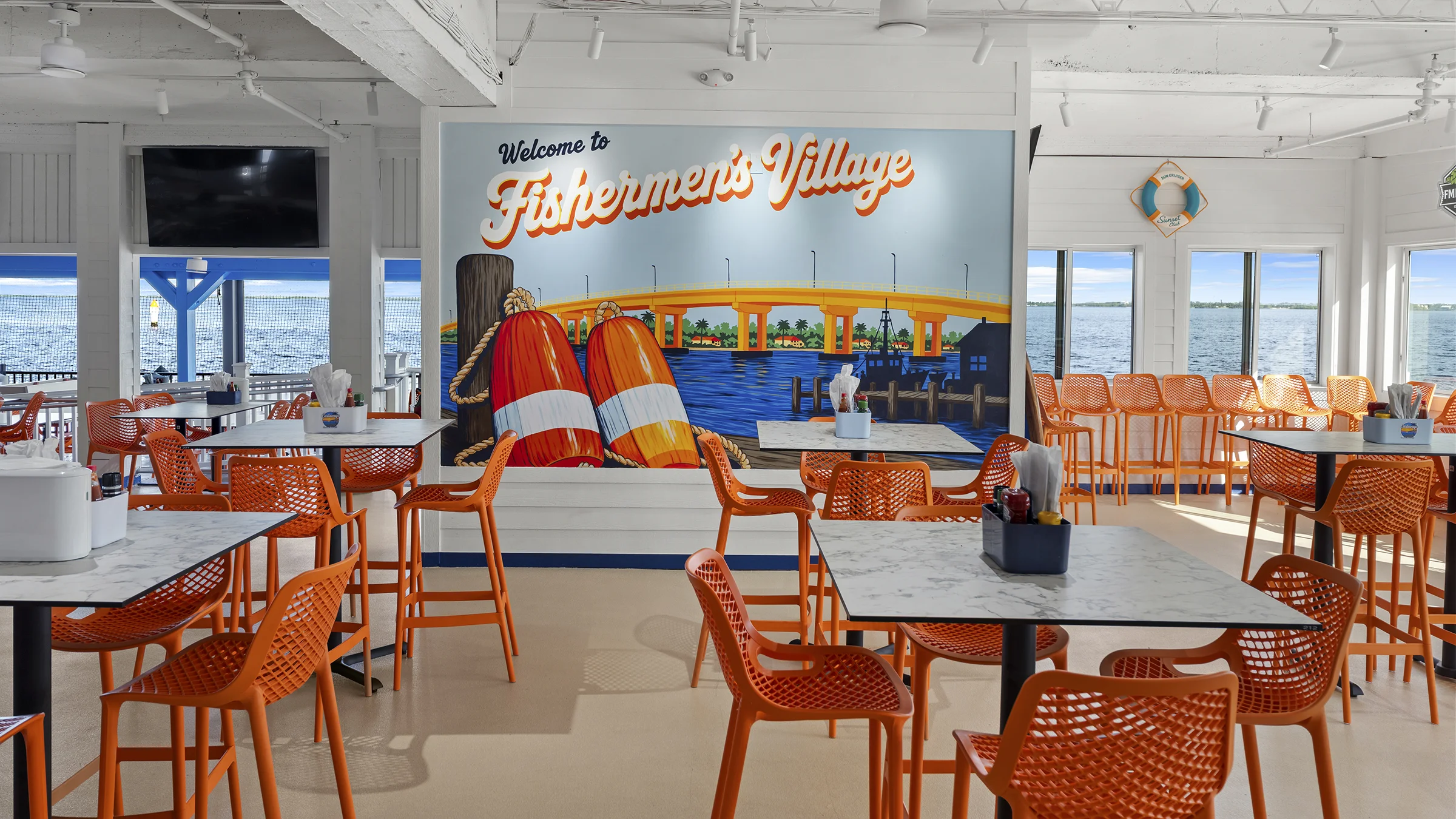 Castaways restaurant with bright orange chairs and mural on the wall that says "Fishing Time".