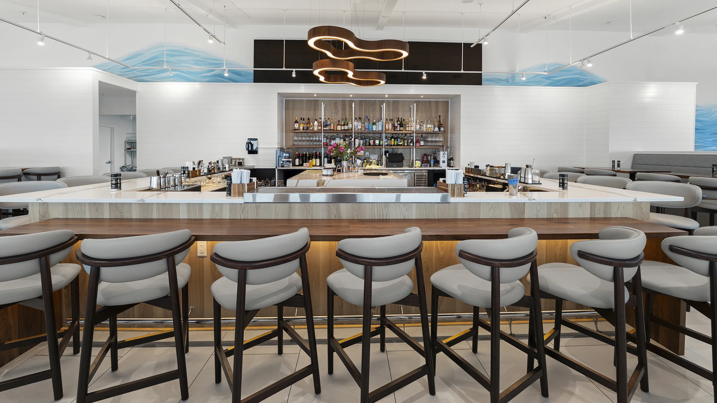 Restaurant bar with elevated seating and a unique light fixture. Located at Latitude 26 in Punta Gorda, FL.