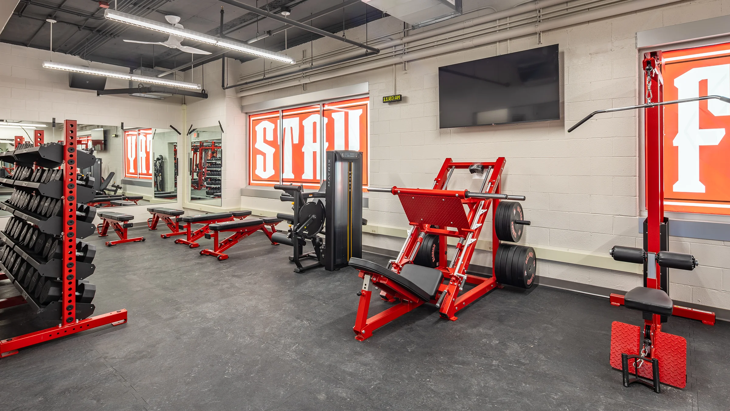 Red weightlifting equipment inside Oak Park High School Athletic Training Center weight room.