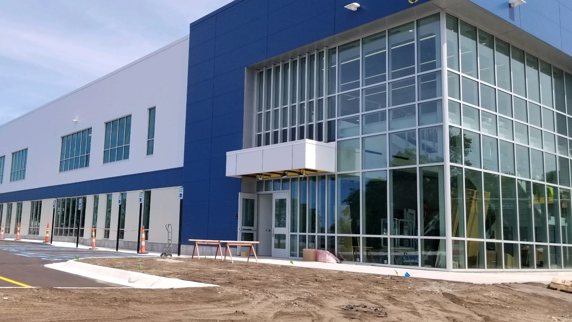 Howmet Aerospace facility in Whitehall, MI. Exterior of building with glass atria and blue and gray facade.