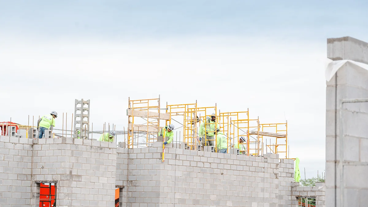 Construction workers laying concrete bricks at Amway Stadium