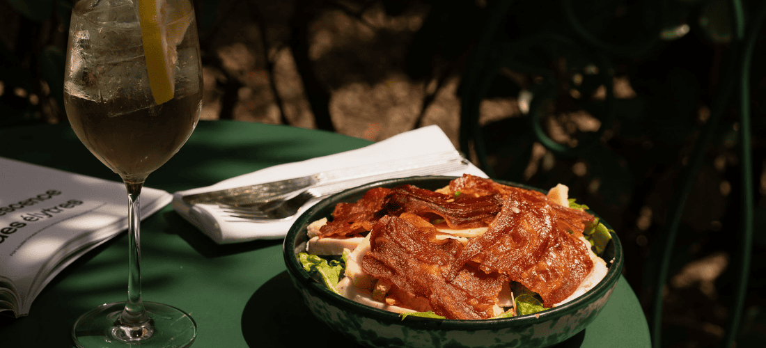 Bowl of food placed on a table with a drink beside it