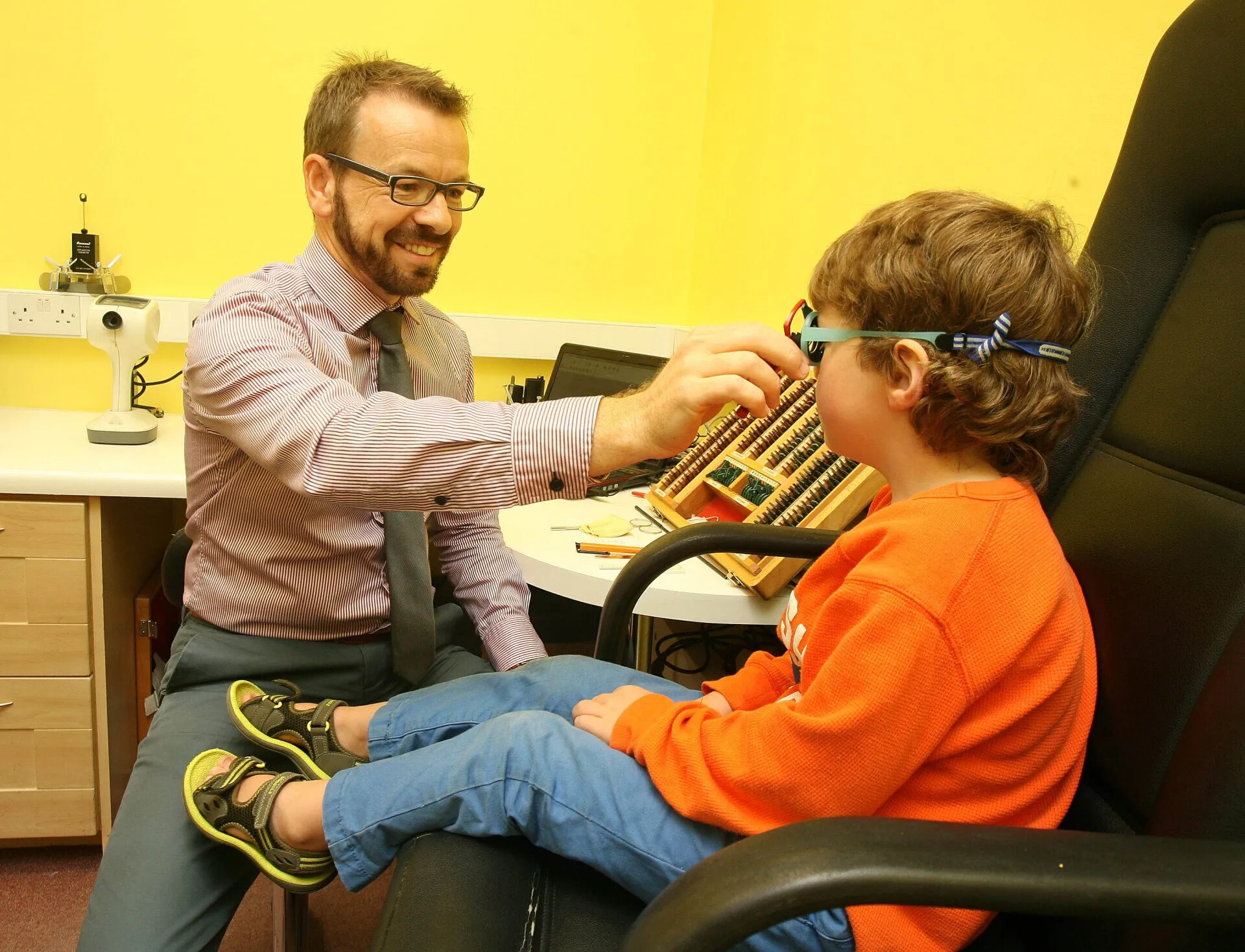 Optician testing kid eyes
