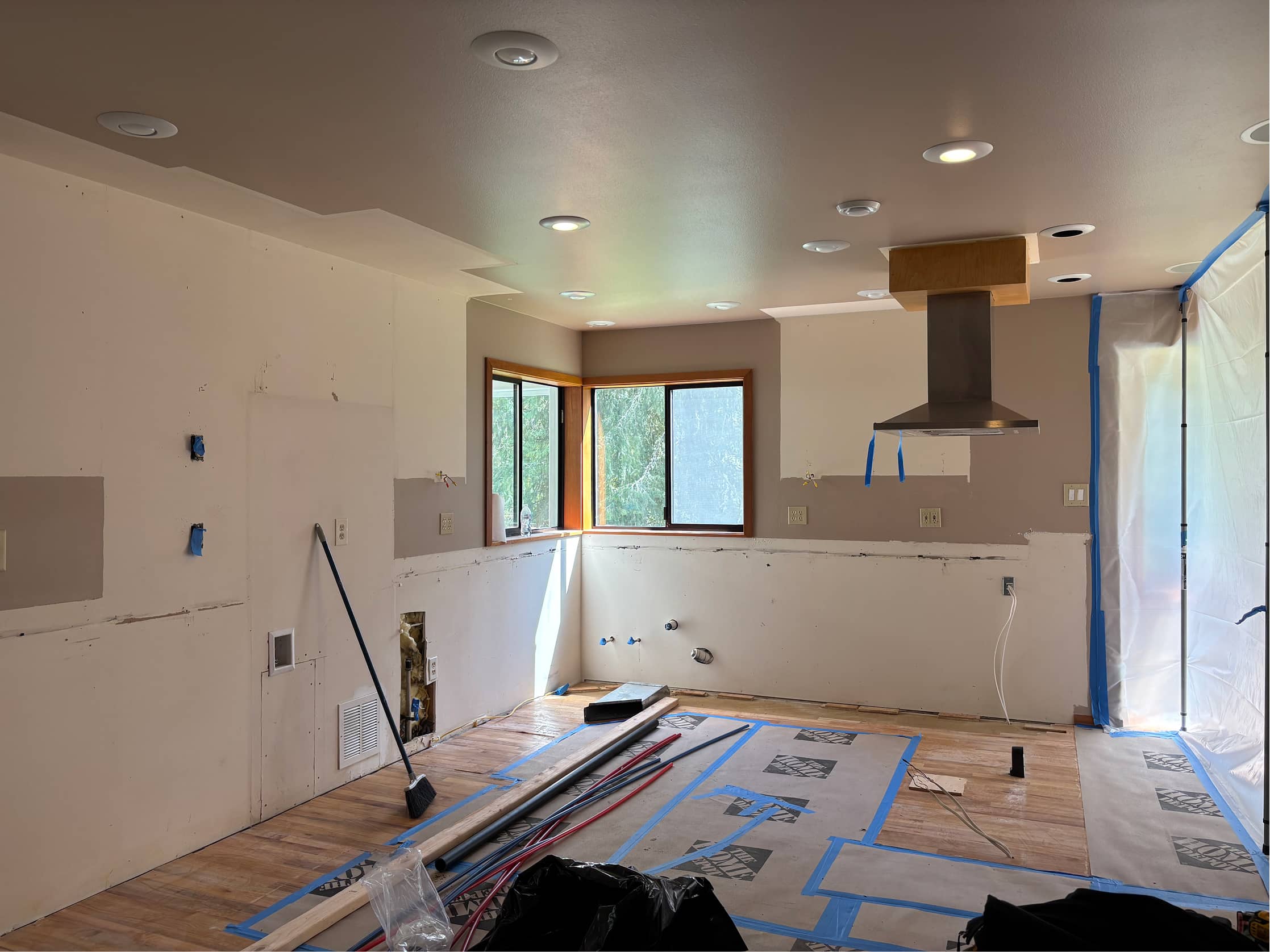 Kitchen remodel in progress with range hood and recessed lighting by NBE LLC