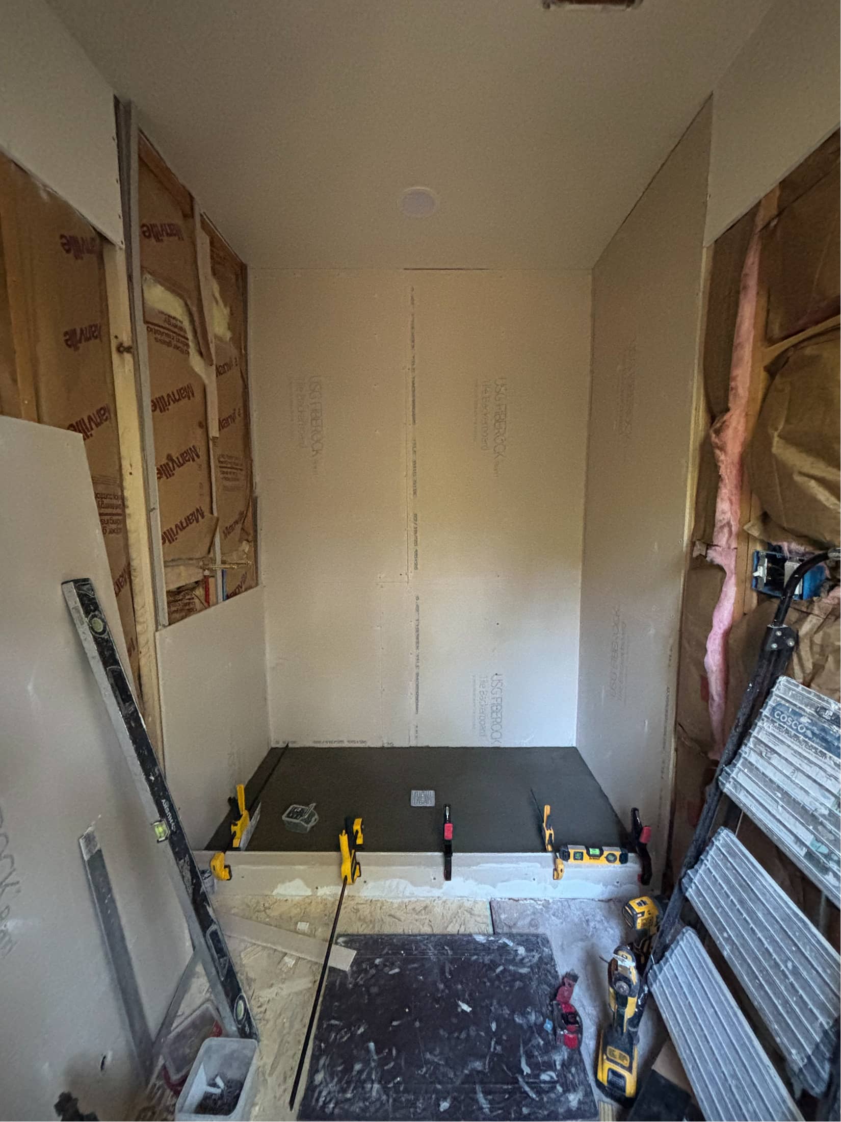 Shower pan installation with drywall and insulation during bathroom remodel by NBE LLC