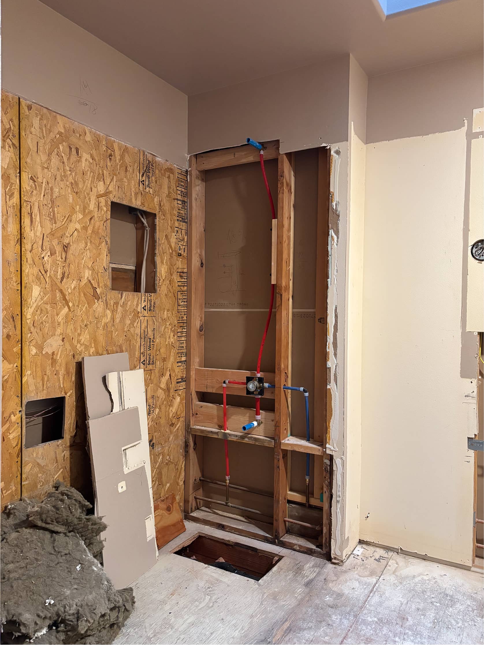 Bathroom remodel plumbing rough-in with exposed framing and PEX lines by NBE LLC