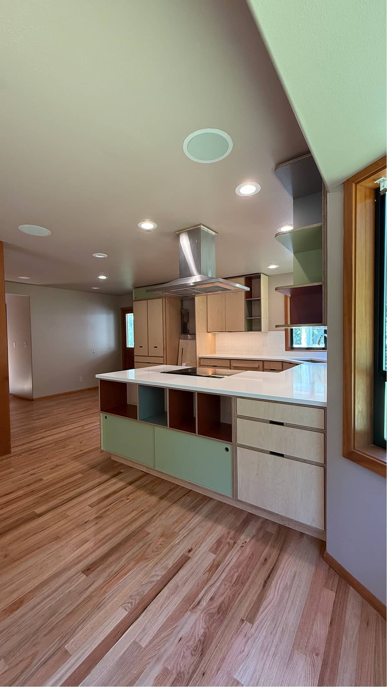 Custom kitchen remodel in Renton with island, range hood and hardwood floors by NBE LLC