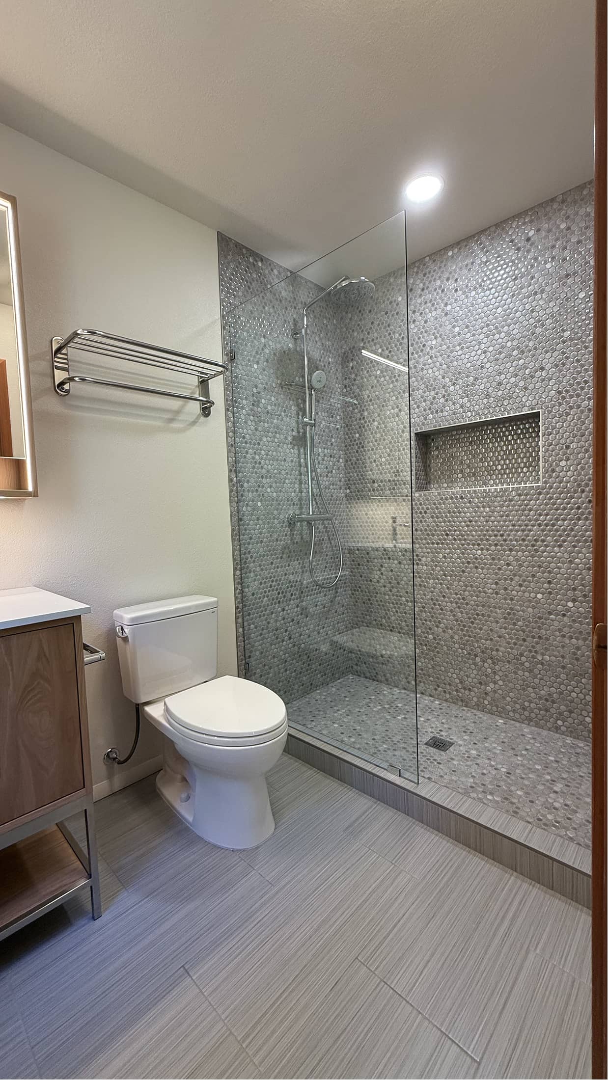 Walk-in shower with mosaic penny tile and glass panel in Renton by NBE LLC