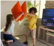 niños jugando a la pelea de almohadas en la sala de casa más 