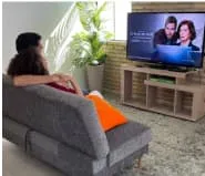 Madre y padre viendo televisión en la sala de casa más