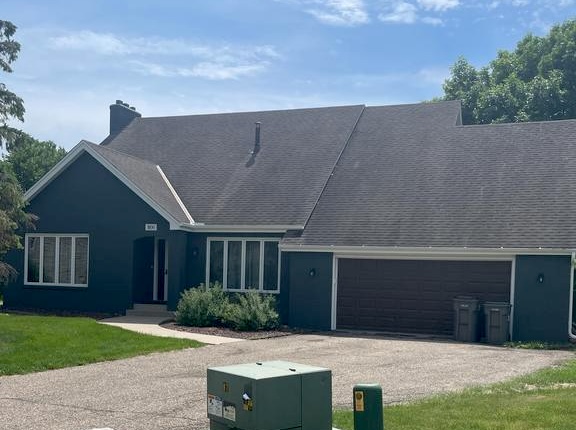 A photo of a house before the new roof was installed, showing old shingles with streaks of black tarnishing