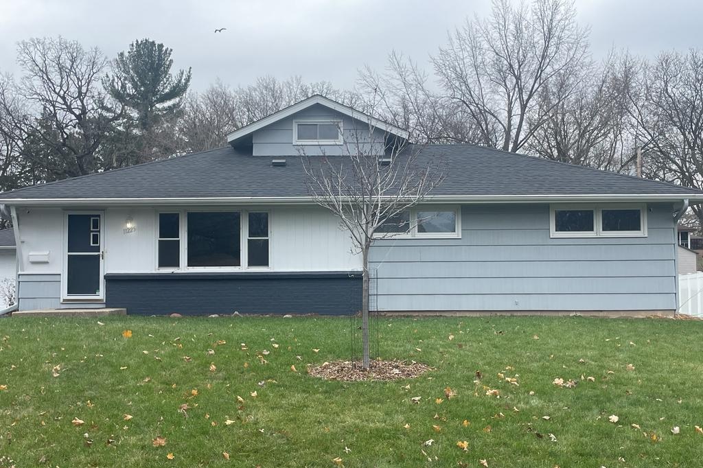 A house before new siding was installed, showing old, weathered light blue siding.