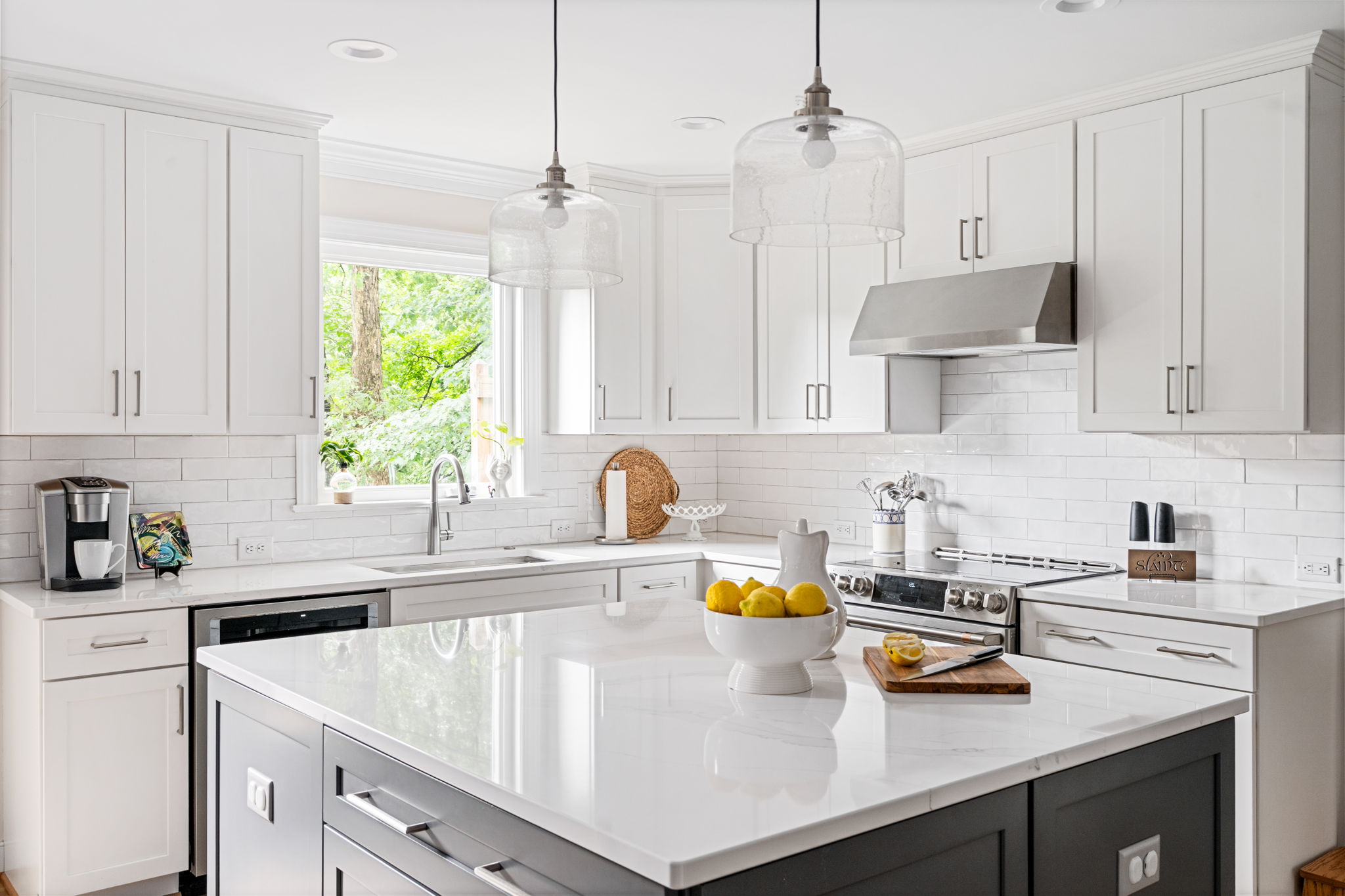View into open-concept kitchen featuring neutral walls, white cabinetry, and modern furnishings after a first-floor addition by Lane Homes & Remodeling.