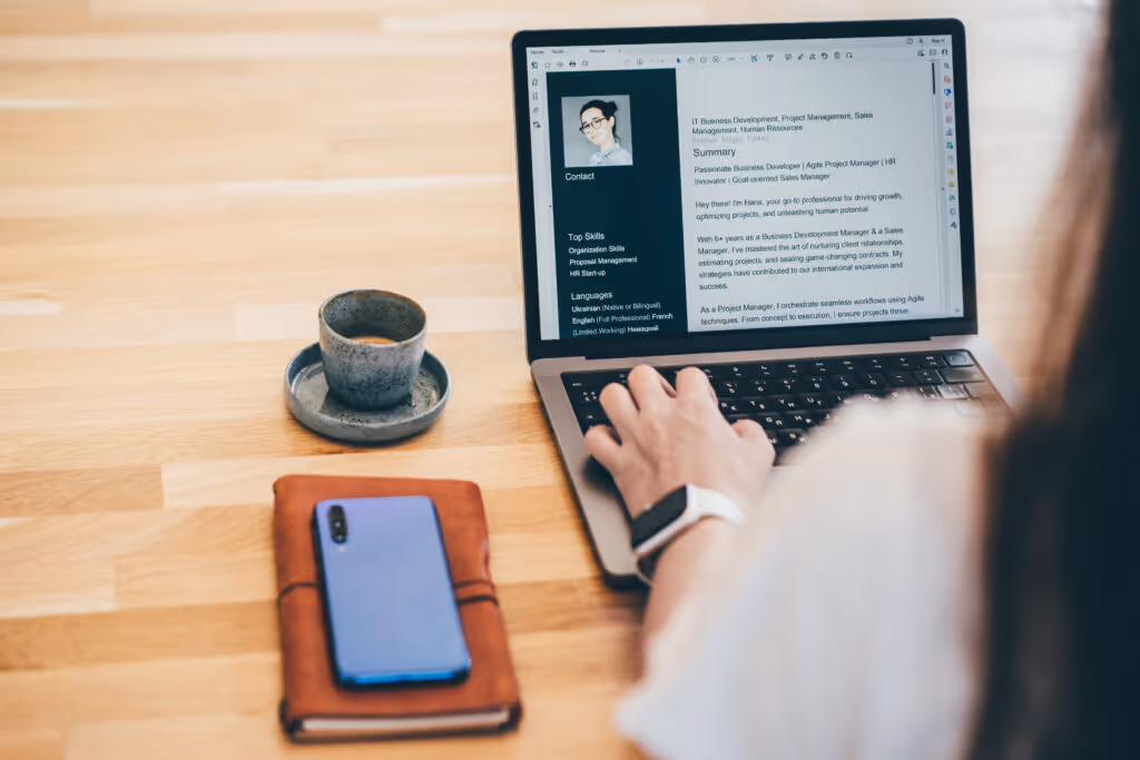 A woman looks at her resume on her laptop which could be enhanced by creating an "About Me" presentation.