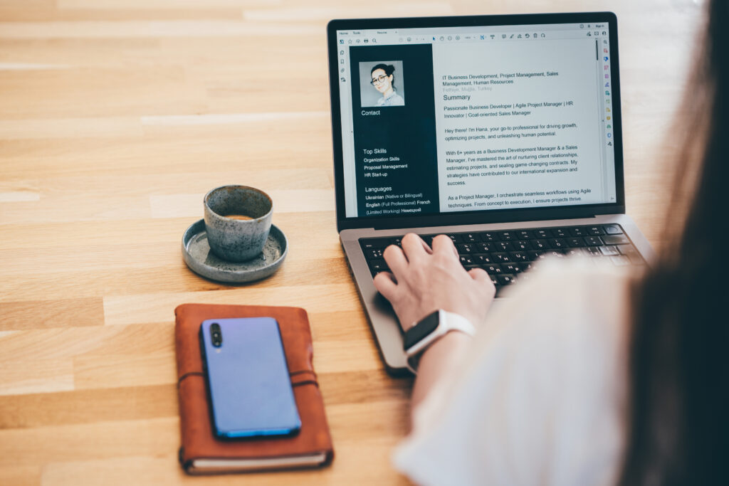 A woman looks at her resume on her laptop which could be enhanced by creating an "About Me" presentation.