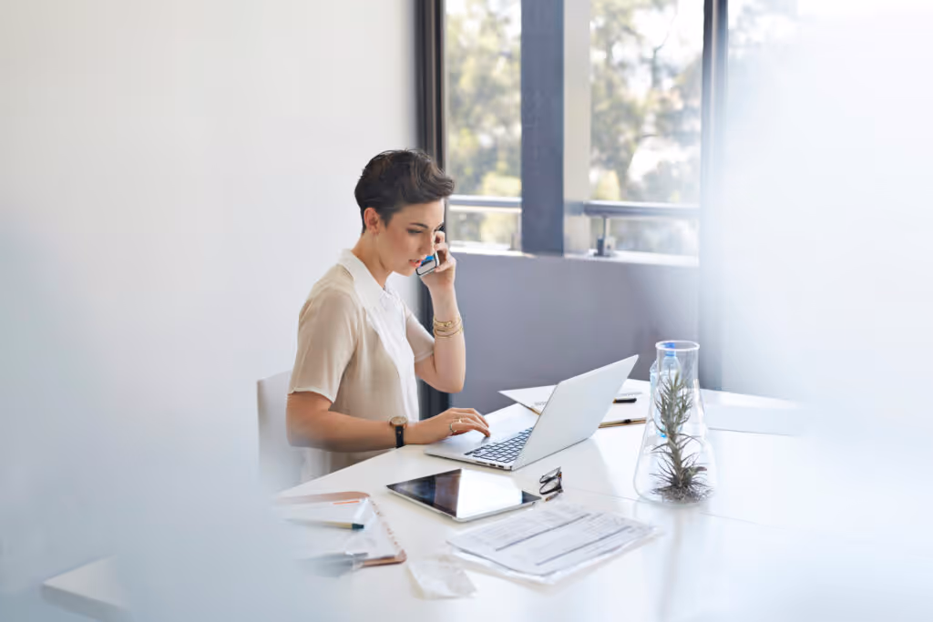 Businesswoman on the phone in front of laptop.
