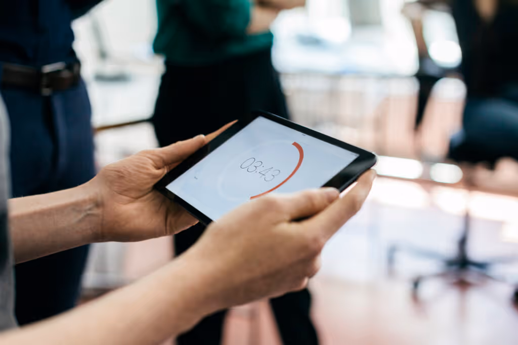 A man holding a timer on a digital tablet during a start up business meeting.