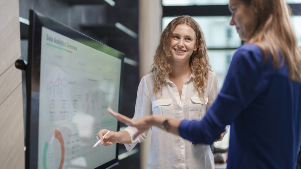 Businesswoman giving presentation to colleagues in meeting room. Business person discussing on data analytics dashboard in meeting room. Shot of a young businesswoman delivering a presentation at a conference.