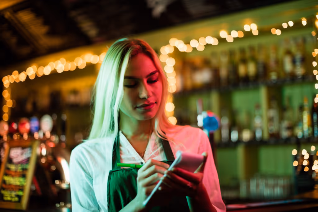 waitress writing order in front of a bar