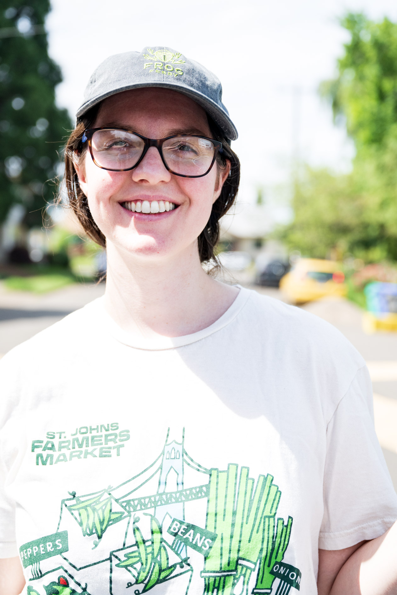 Lena smiles in a ballcap and glasses