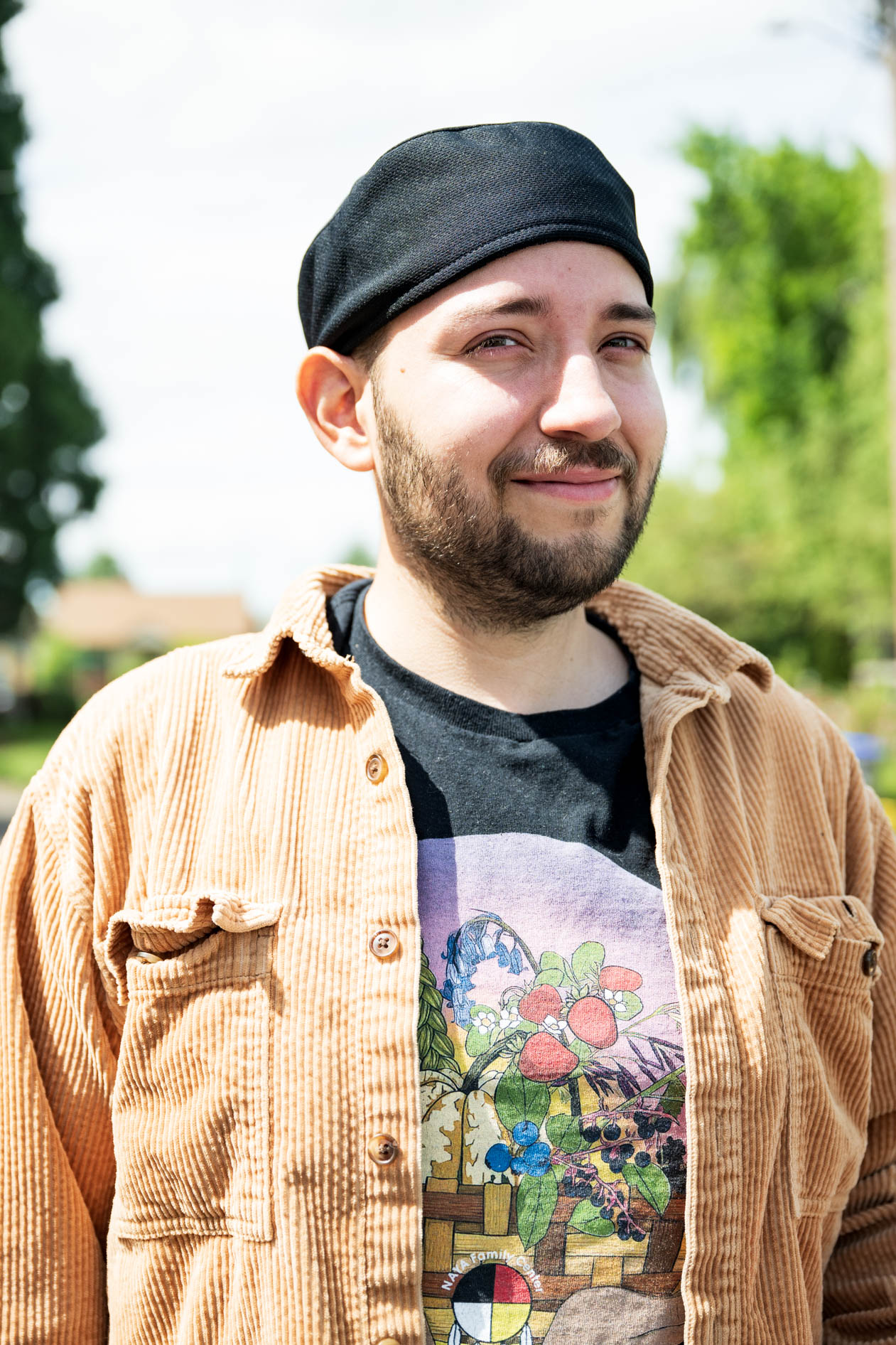Juan stands proudly in a brown jacket and head wrap