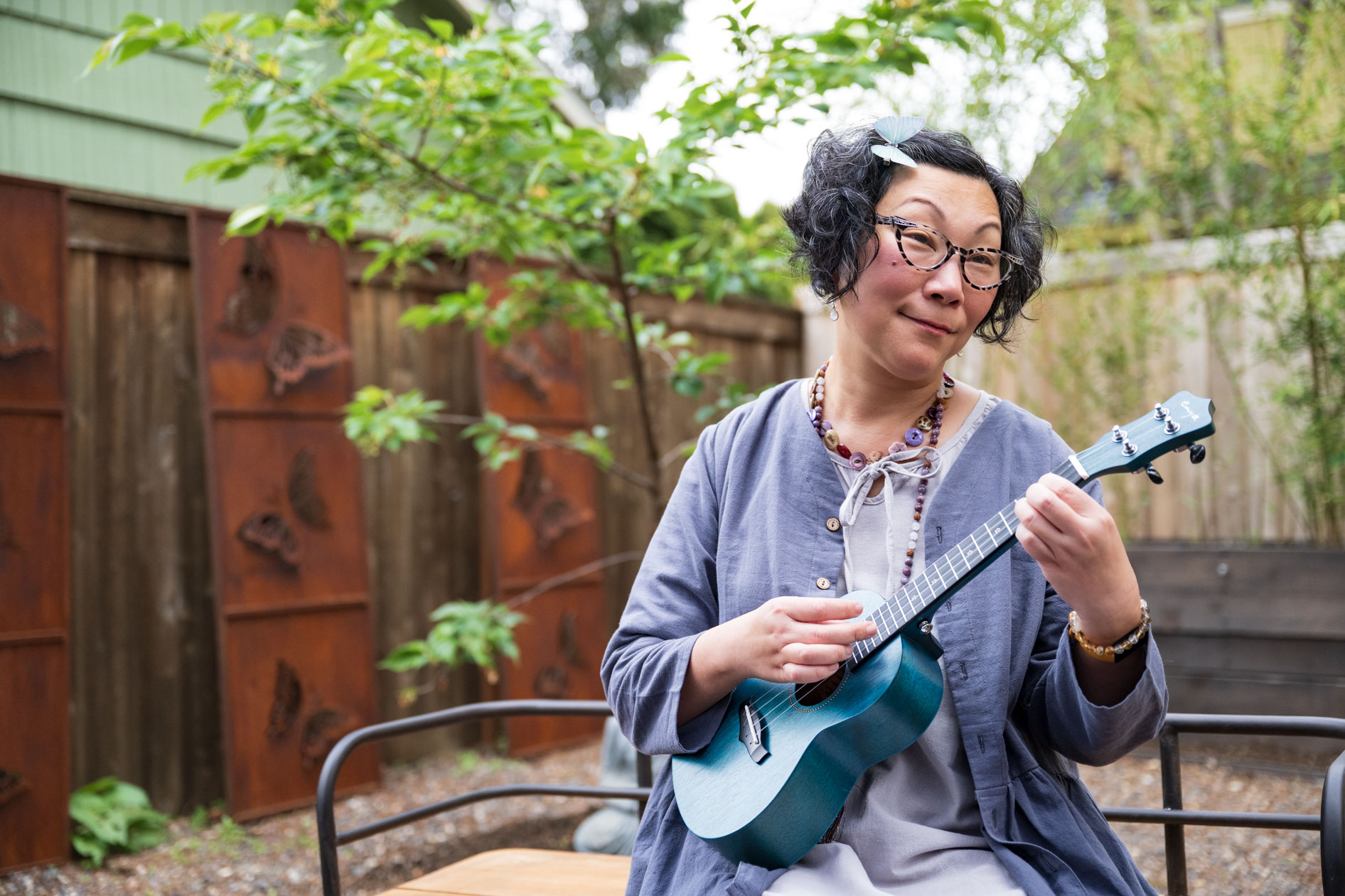 sally moon plays a ukelele in her backyard in portland