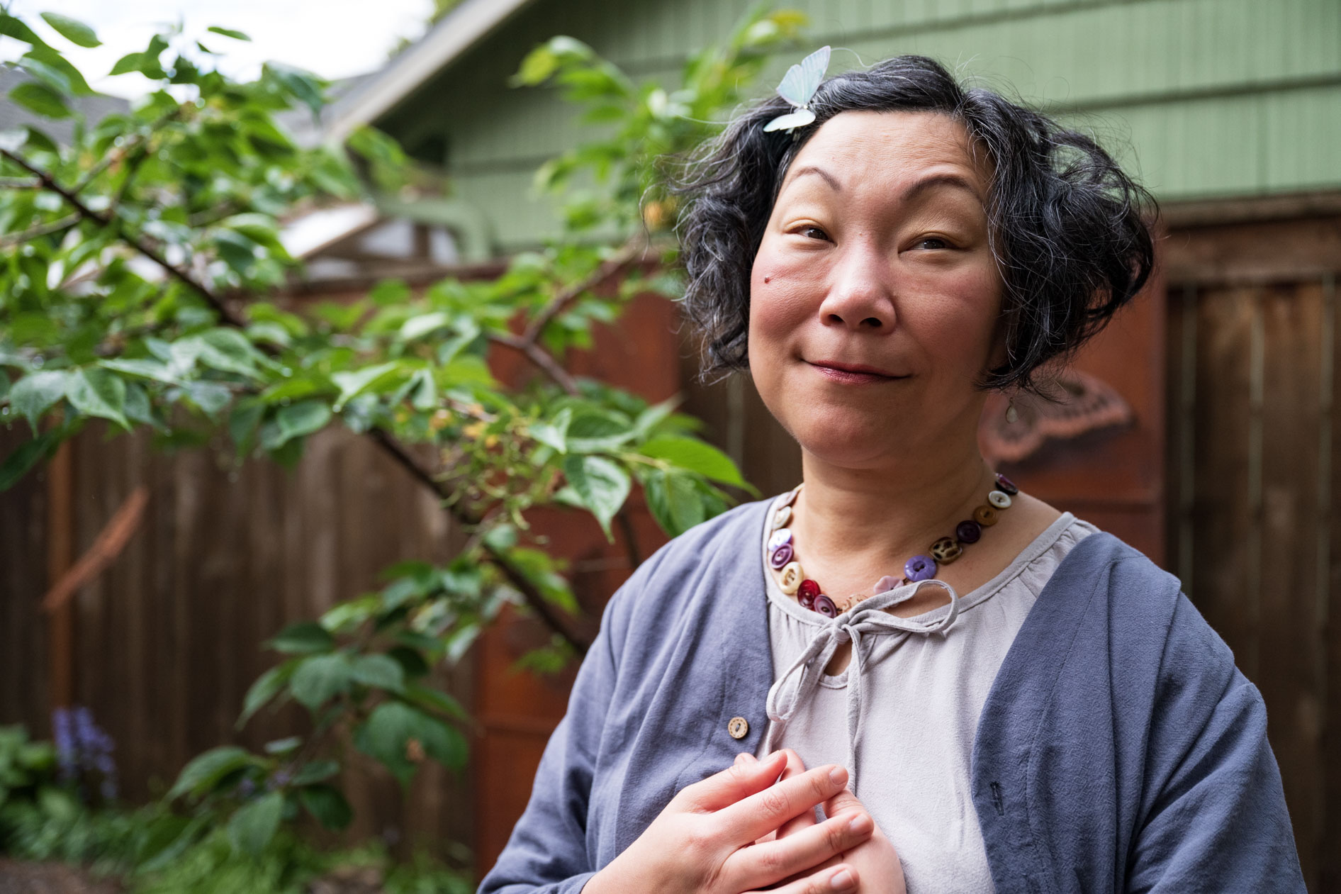 sally moon lee clasps her heart in her portland backyard
