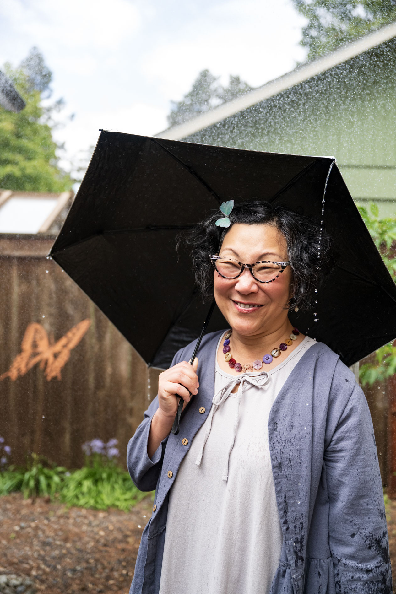 portland meditator sally moon lee laughs while shielding herself from the portland rain