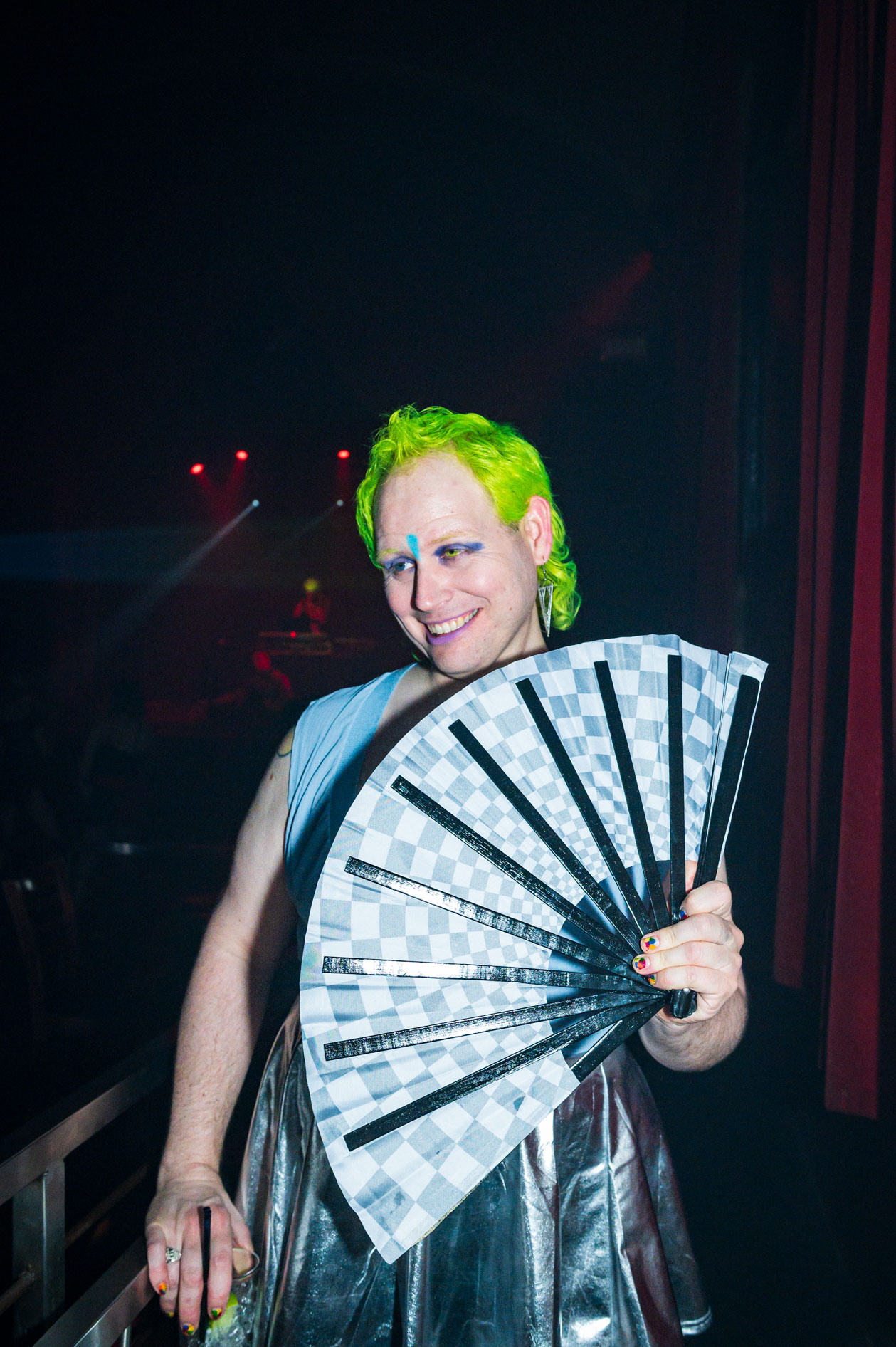 a party-goer with green hair poses with a fan at a dance event in downtown Portland