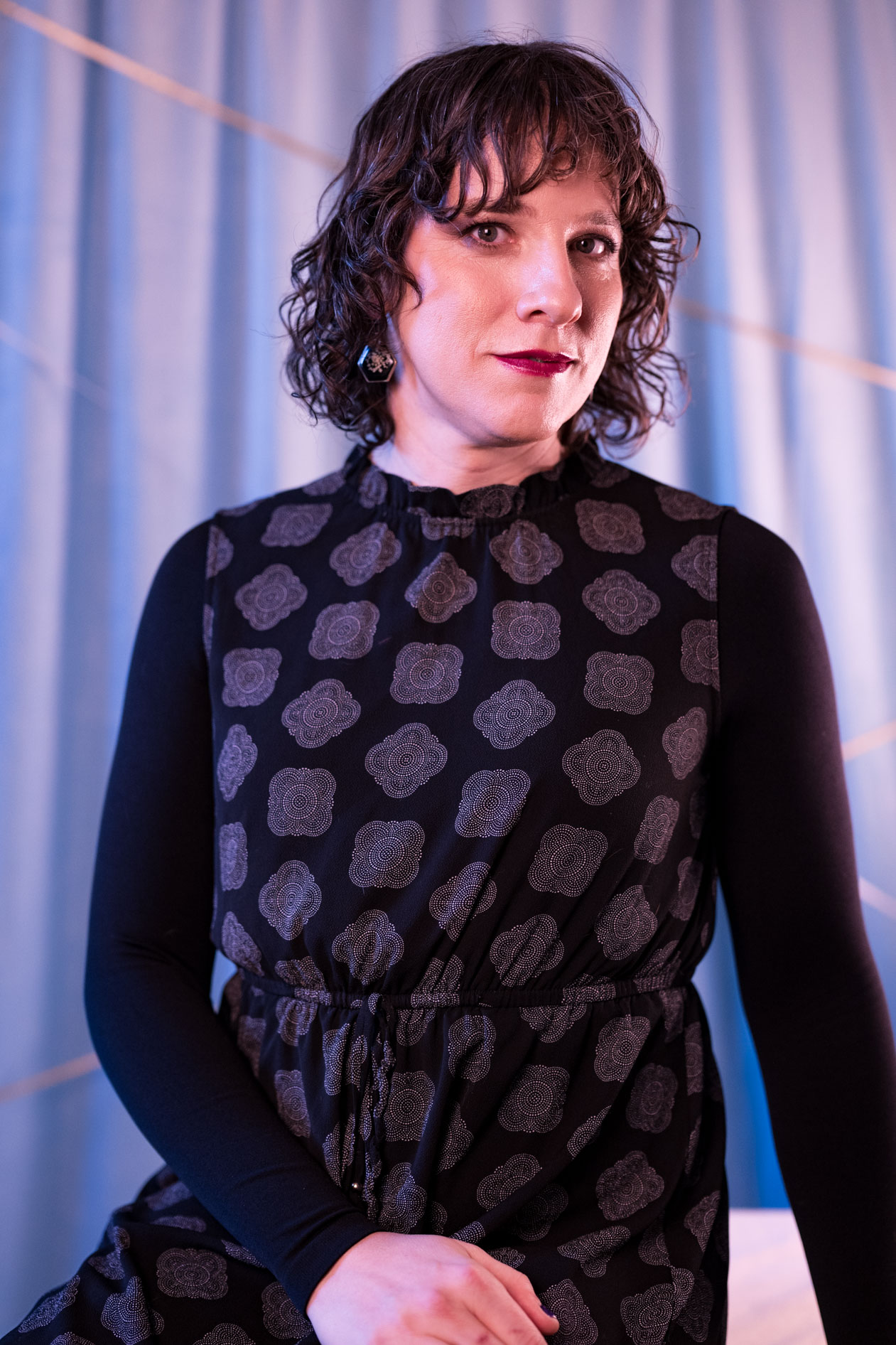 a brightly lit trans woman sitting in a SE Portland studio