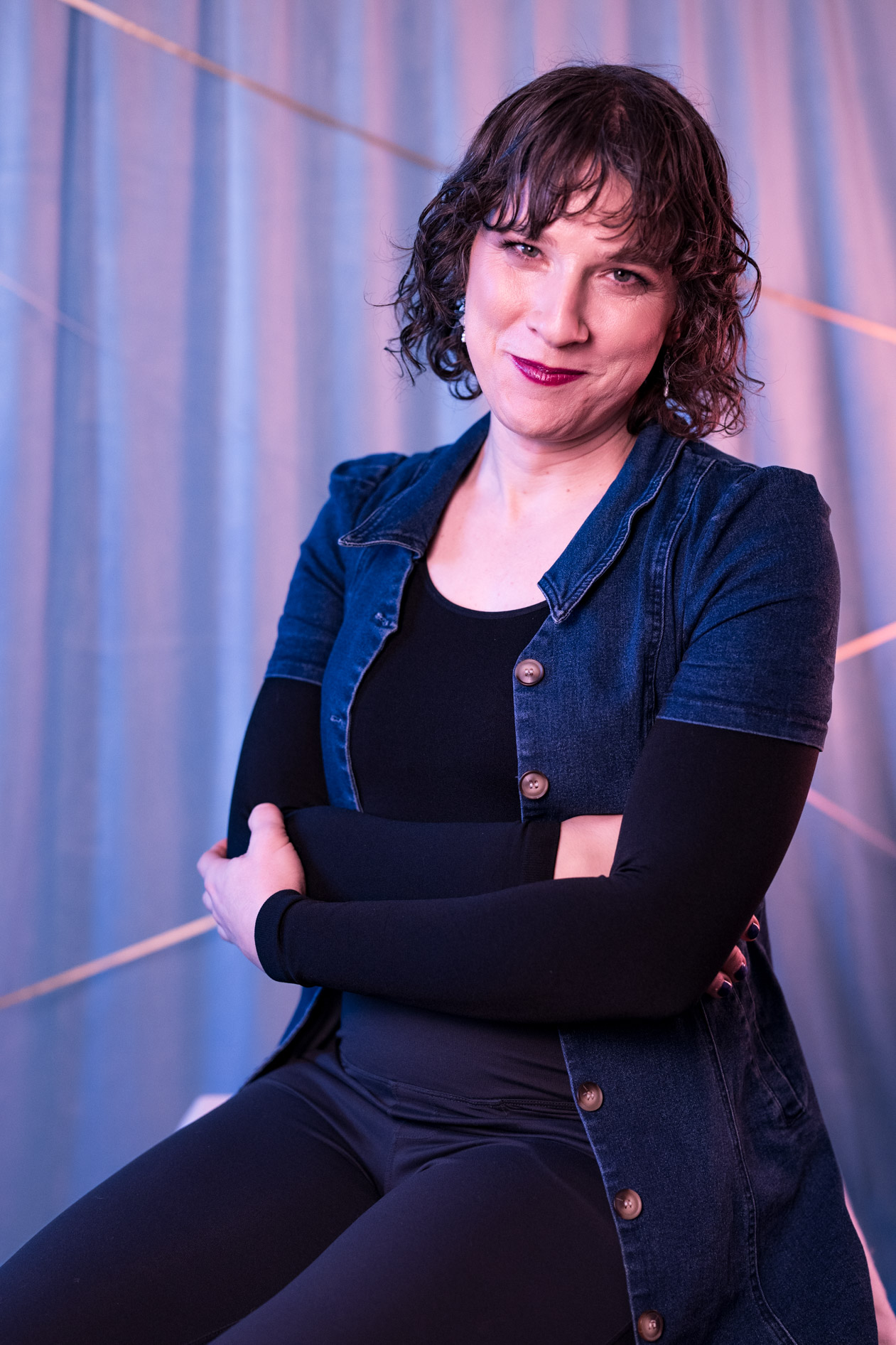 a beautiful trans woman poses with arms crossed in the Portland studio