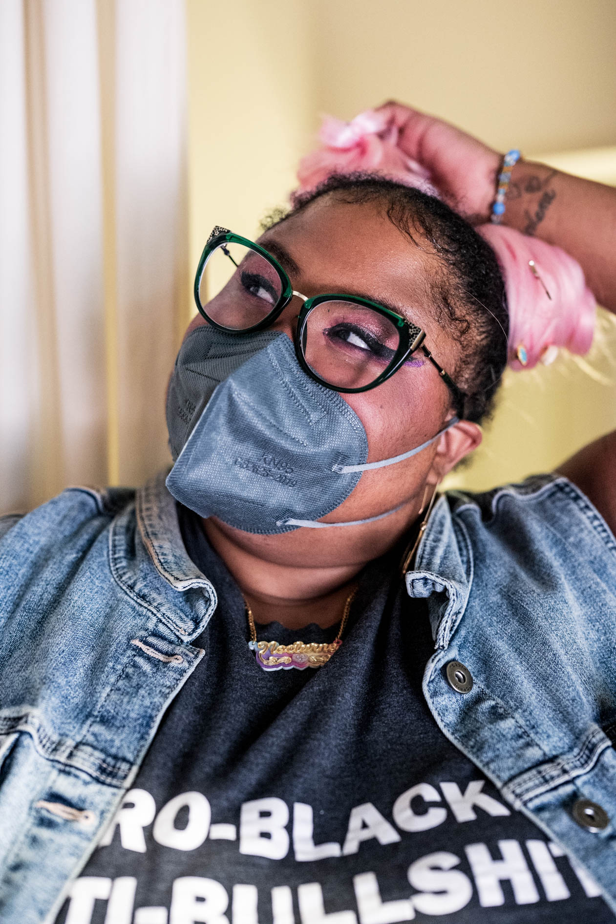 A candid commercial photograph of a smiling person with pink hair, glasses, and a mask, looking up and to the side. This image is for a case study with Affect's Disabled and Here series, highlighting T4T pride in Portland, Oregon.