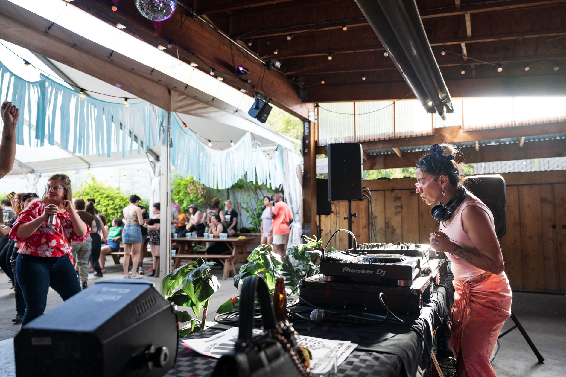 A candid photograph of DJ Lapaushi performing a set at a live event in Southeast Portland. This image showcases commercial photography and brand storytelling for an artist's portfolio.