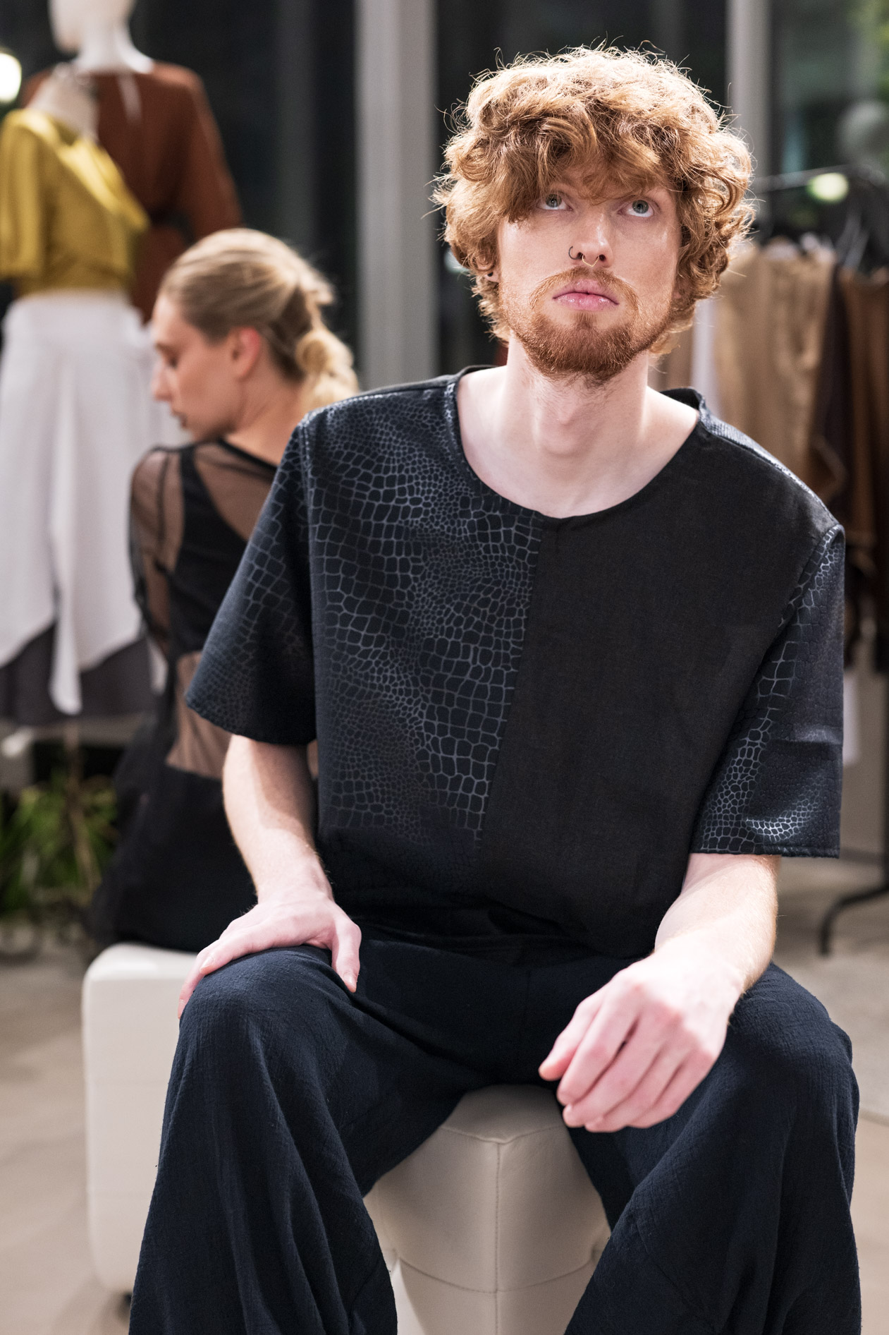 A commercial portrait of a male model with reddish hair and beard, wearing a black shirt and pants from the boutique brand Ale O. This image showcases lifestyle brand photography in Portland, Oregon.