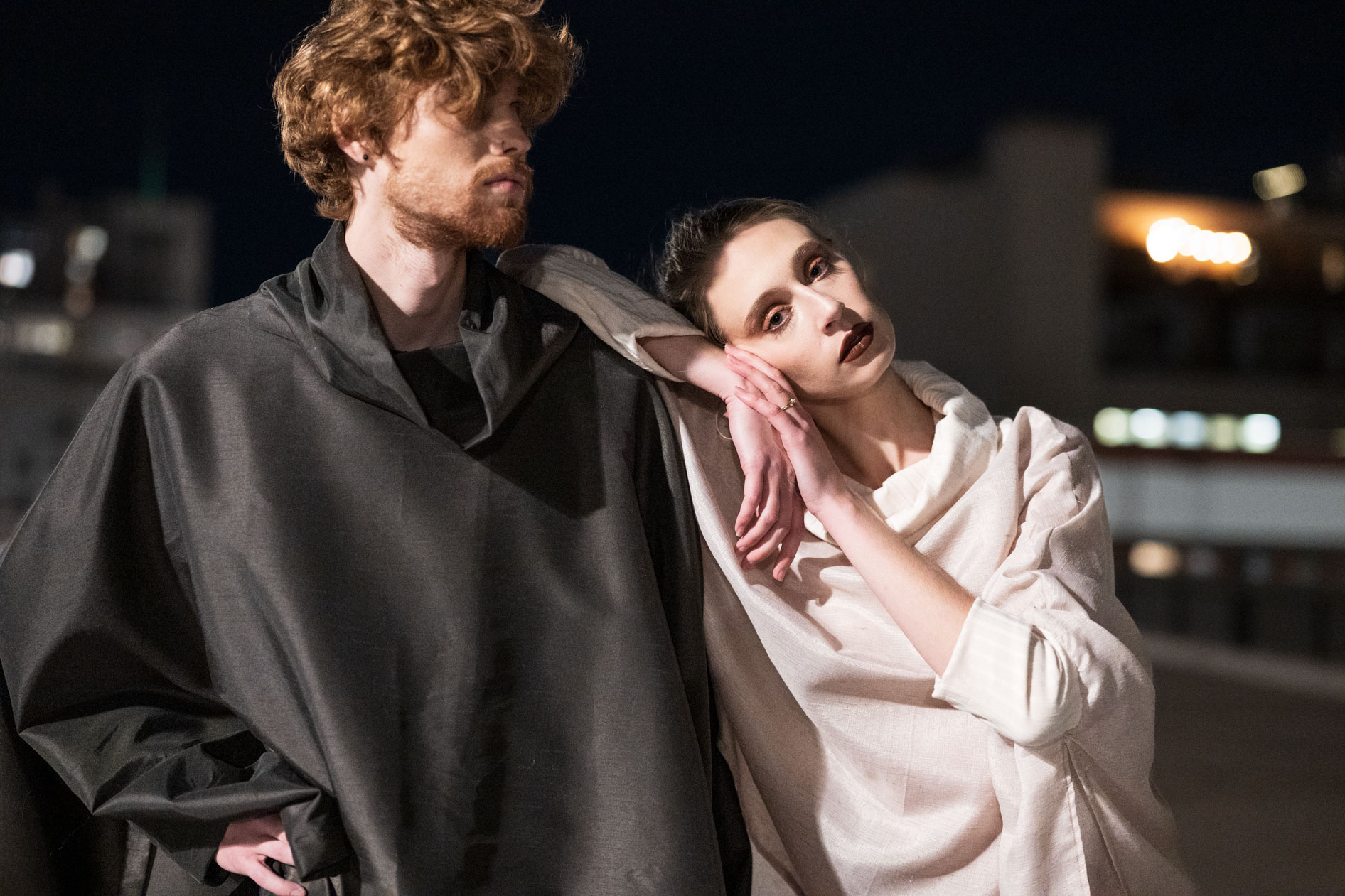 A commercial portrait of two models wearing clothing from the boutique brand Ale O, posing at night with the city lights in the background. This image showcases lifestyle brand photography in Portland, Oregon.
