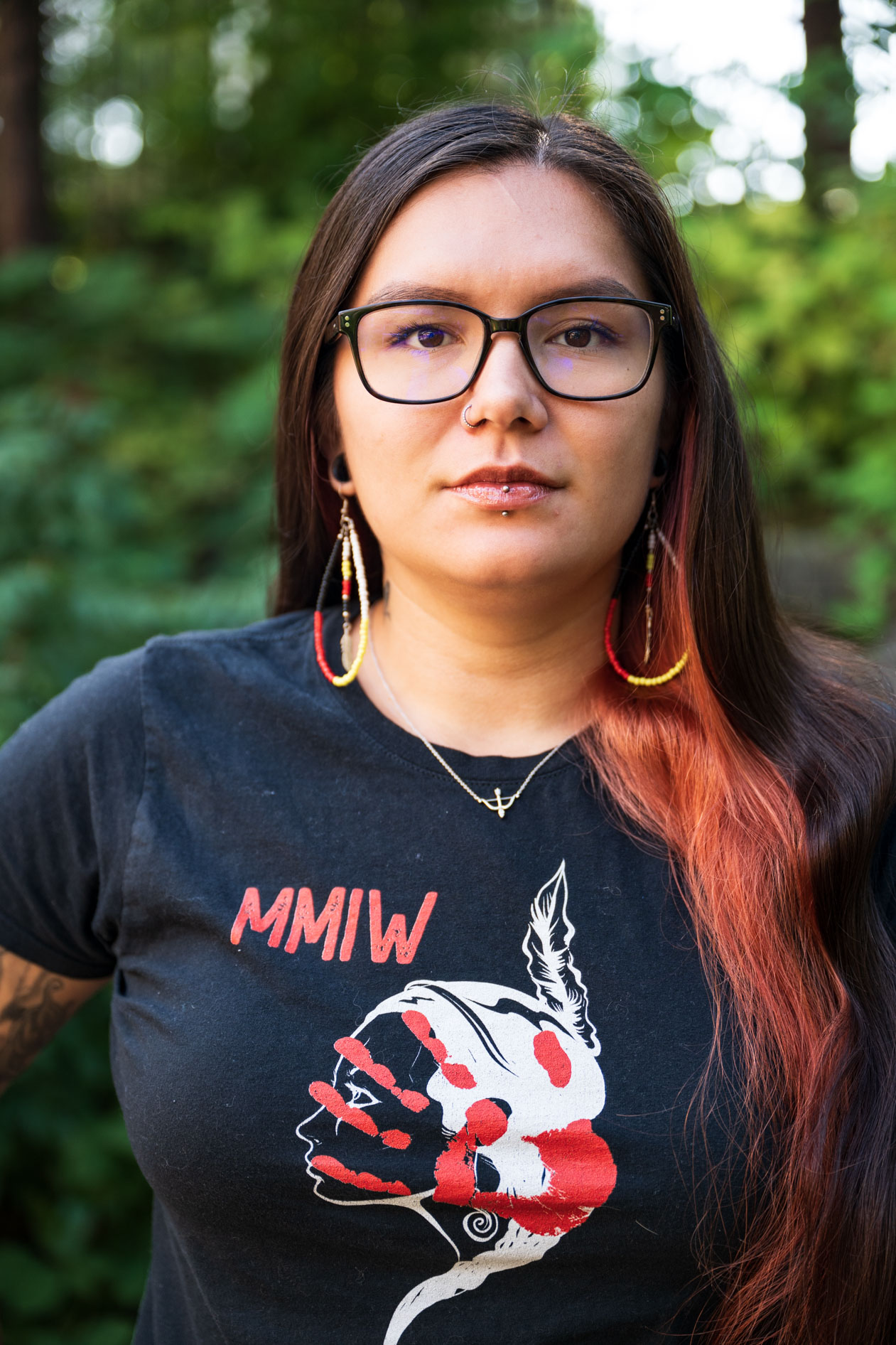 A portrait of a JREP grantee wearing an MMIW shirt and beaded earrings, captured at the Northwest Health Foundation event.