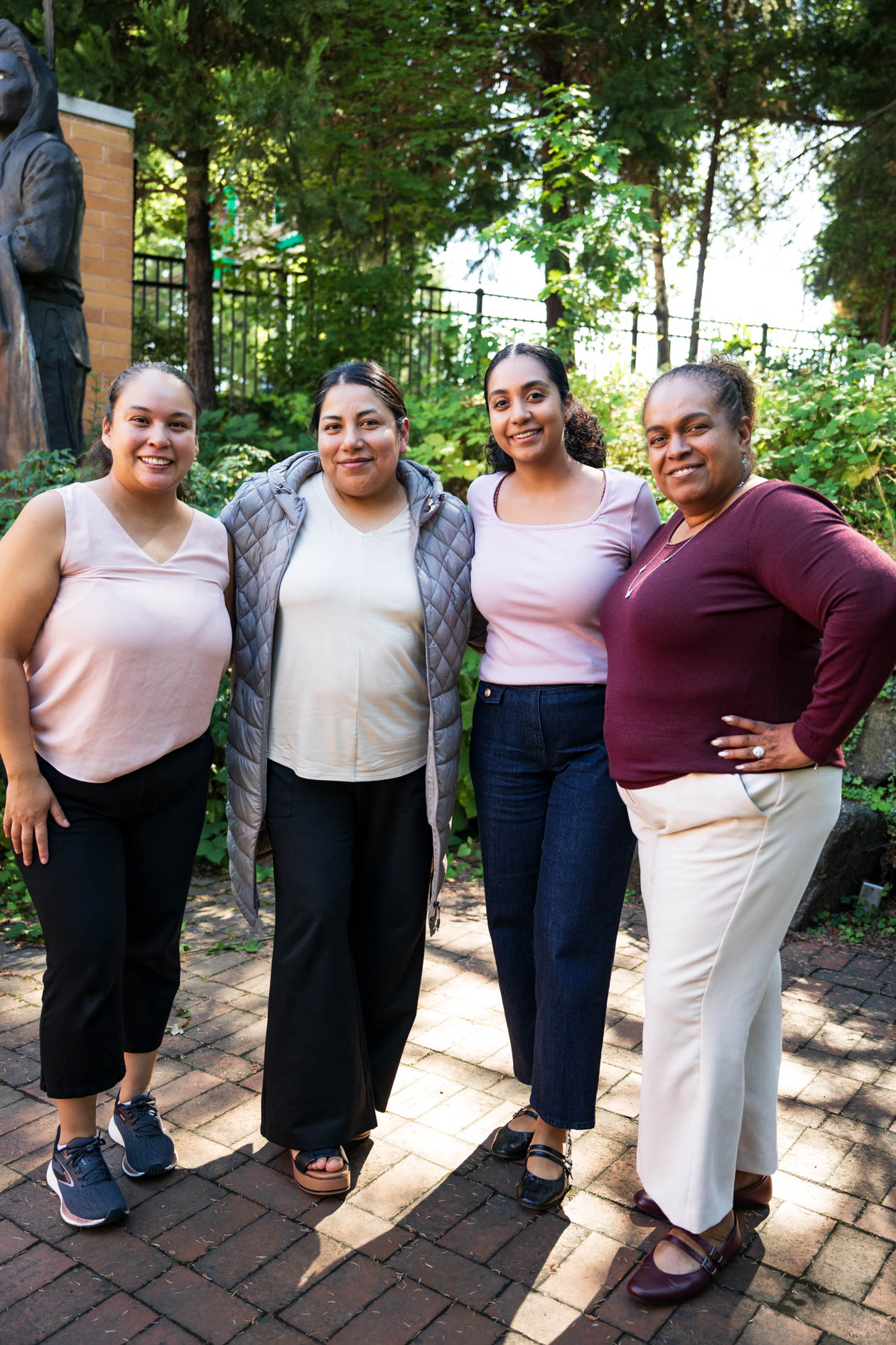 A candid group photo of four smiling JREP grantees posing together outdoors at the Northwest Health Foundation convening event.