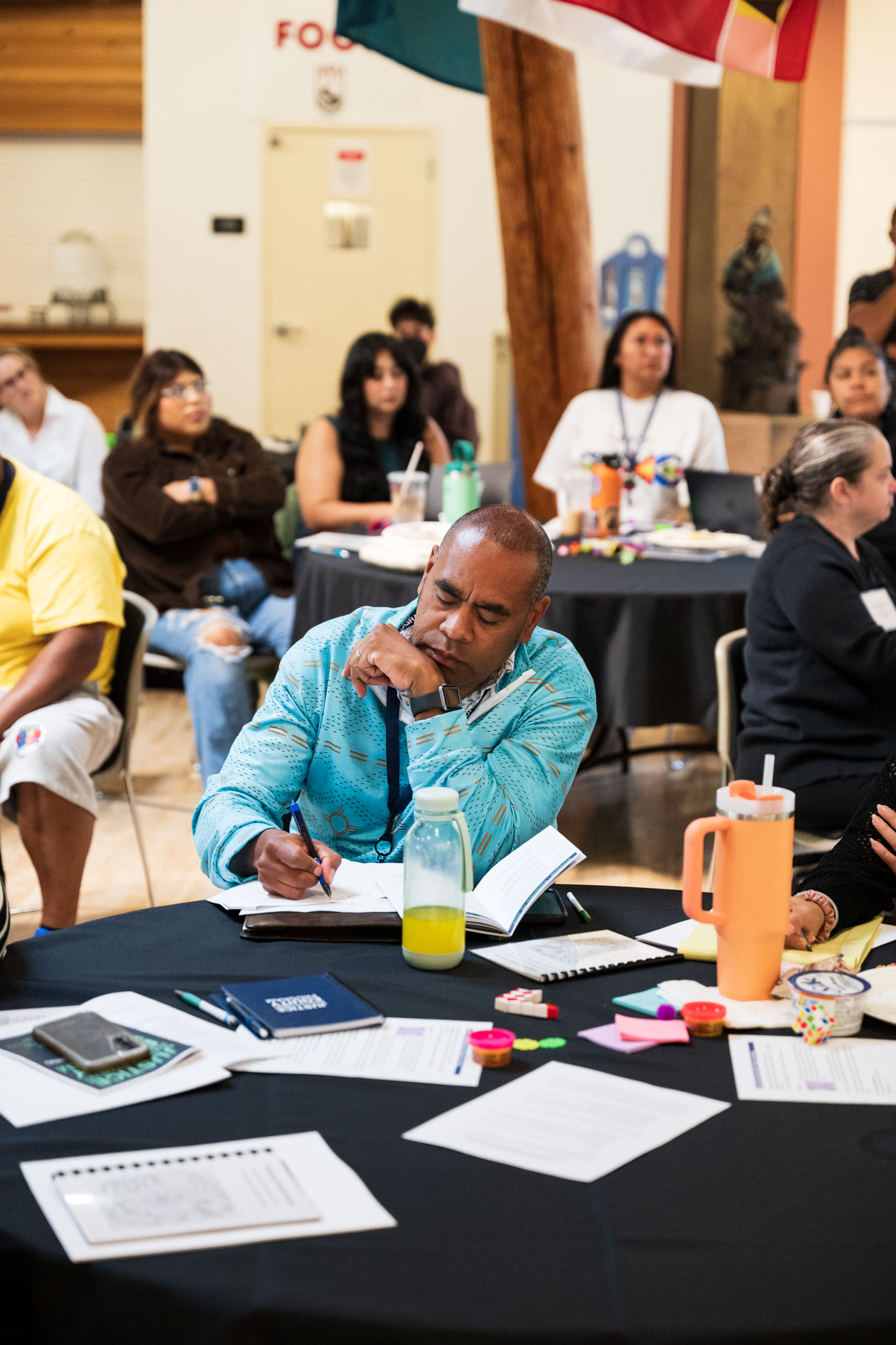A candid photograph of a JREP grantee taking notes at a table during the Northwest Health Foundation convening event.
