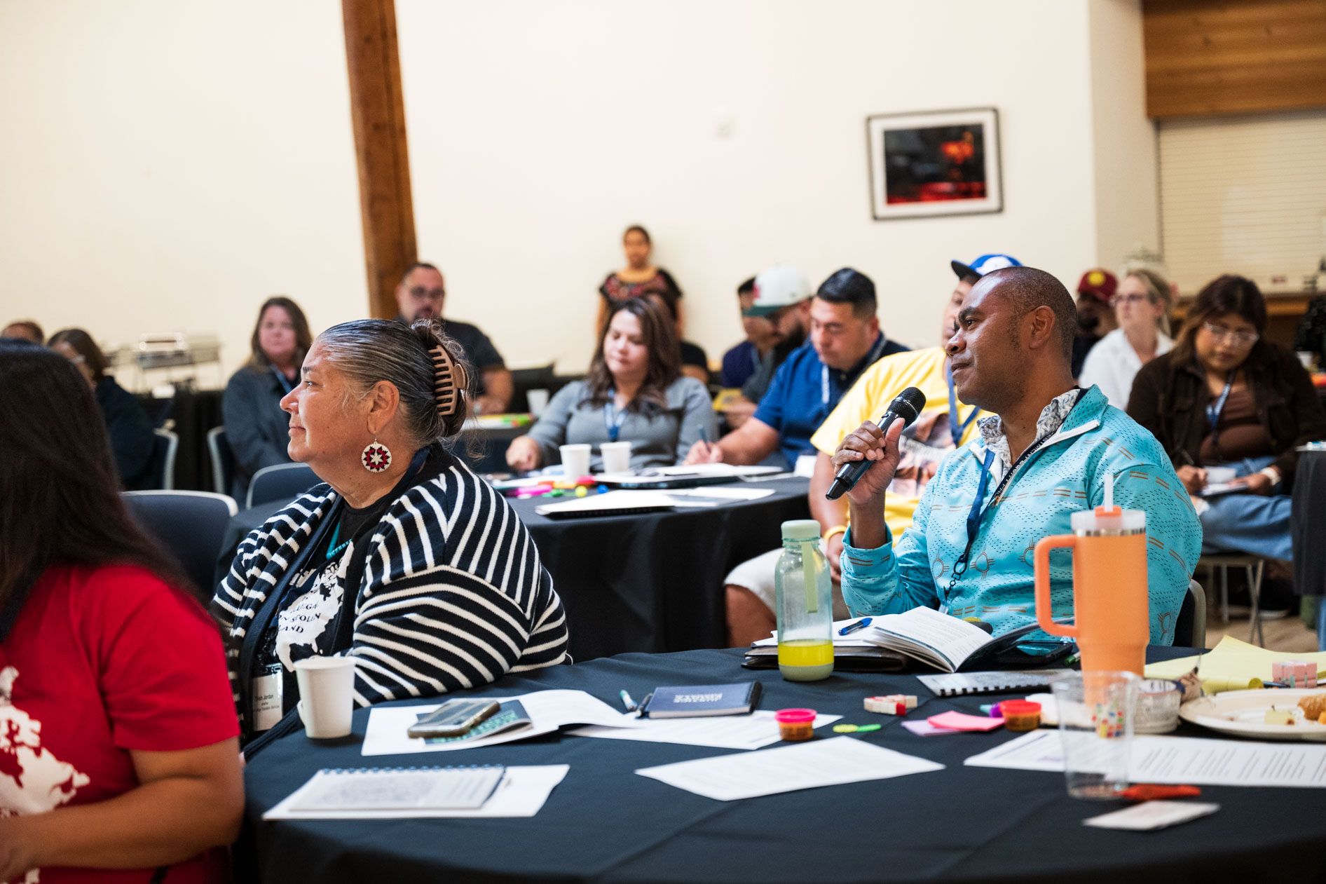 A candid photograph of a JREP grantee speaking into a microphone during a discussion at the Northwest Health Foundation convening event.