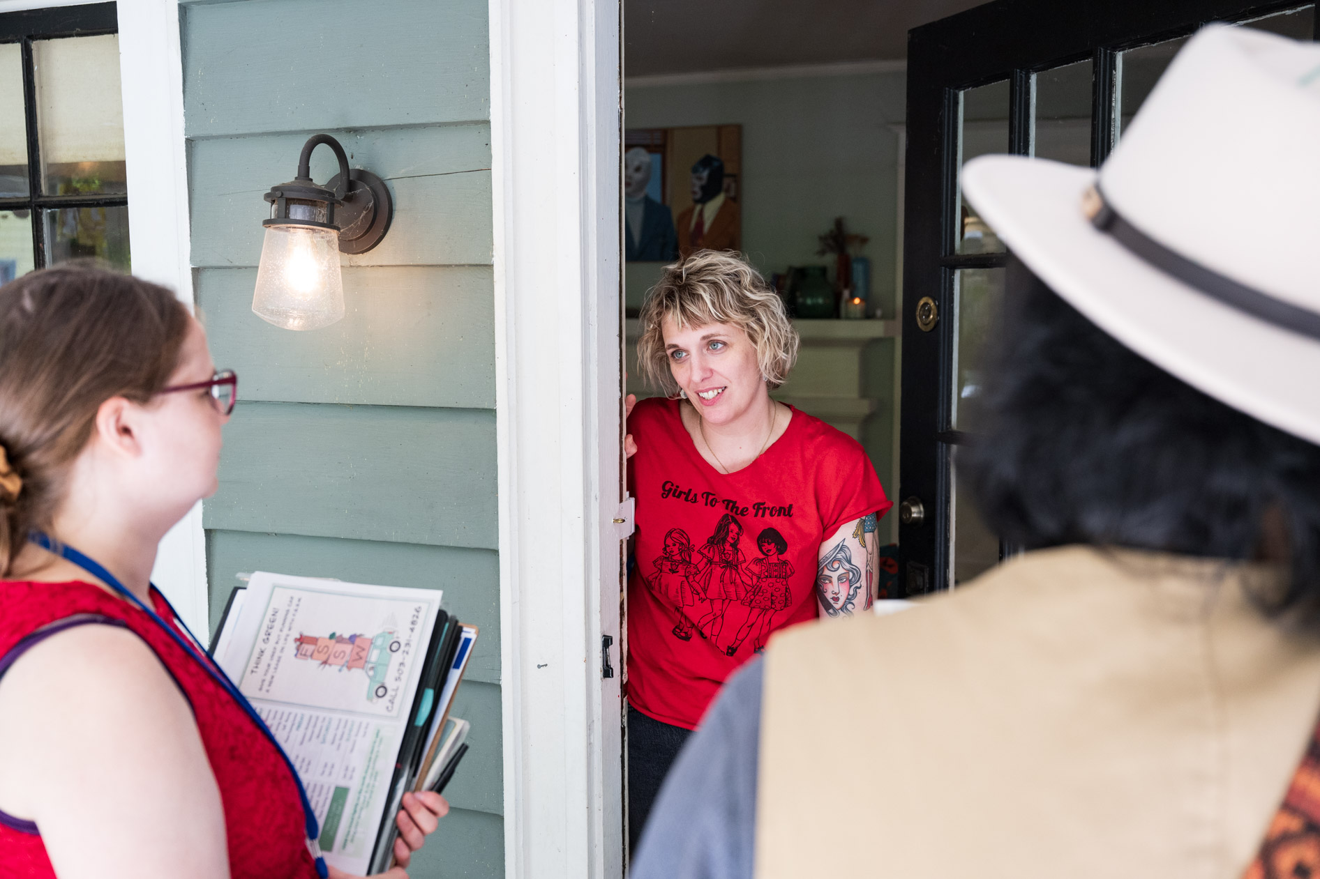 A Friends of Seasonal and Service Workers (FSSW) volunteer talks with a resident at their doorway while canvassing for the annual food drive.