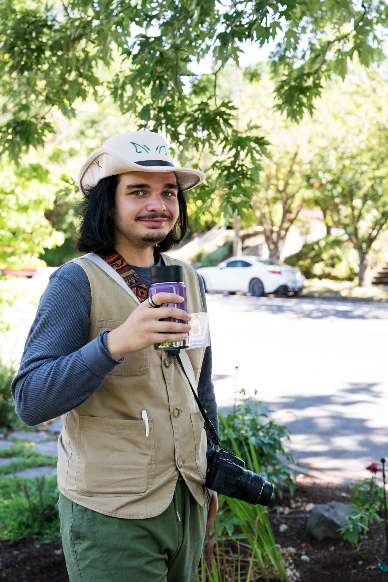 A volunteer for Friends of Seasonal and Service Workers (FSSW) pauses while canvassing, holding a travel mug. This showcases nonprofit photography in SE Portland.