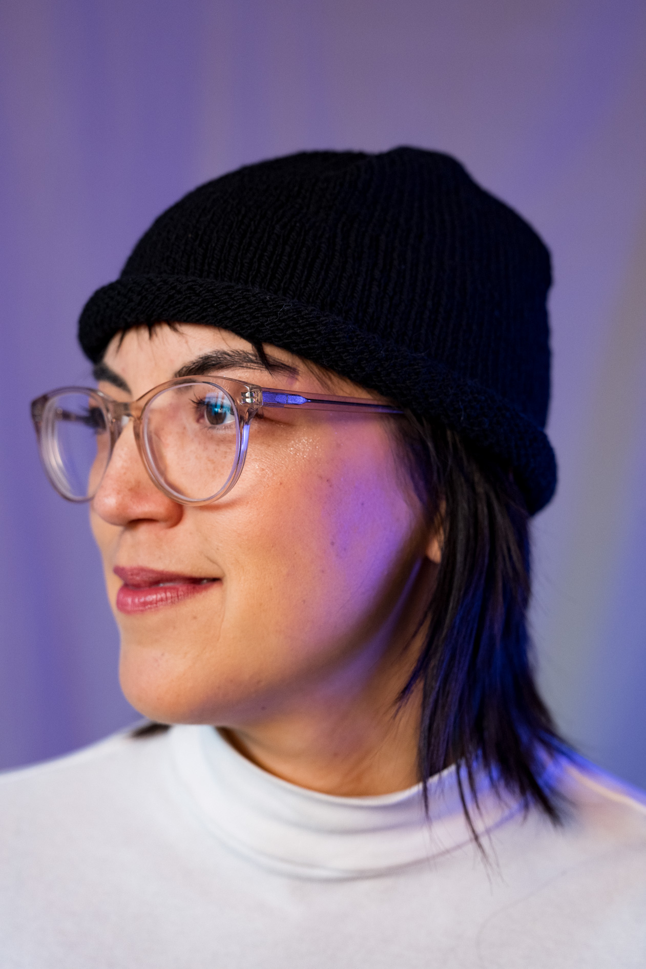 A close-up, smiling inclusive portrait of Lee DeJonge wearing a knit beanie and glasses. This showcases creative portraits in Portland, Oregon.