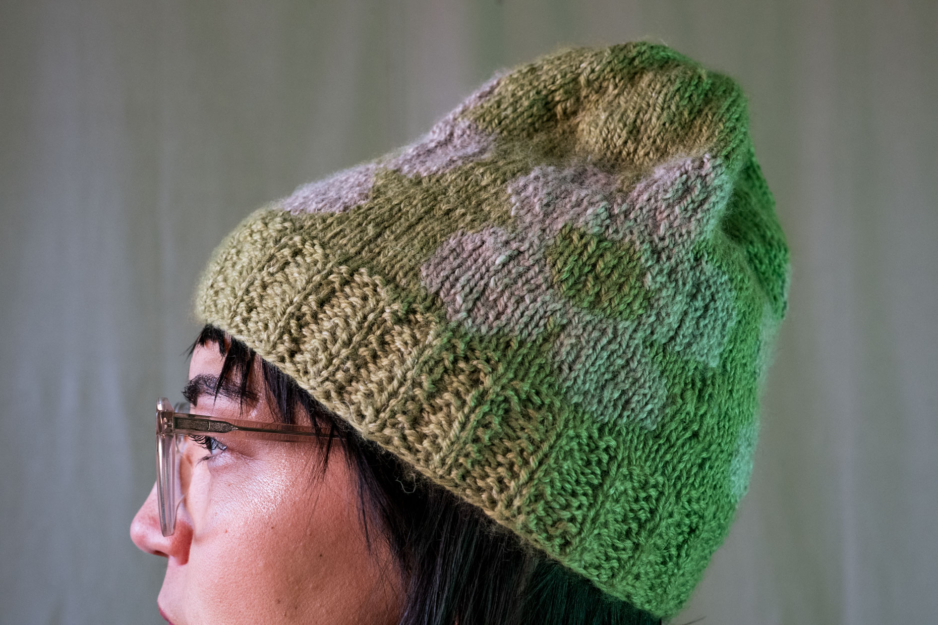 A profile portrait of Lee DeJonge wearing a custom-knit green and white beanie. This highlights creative portraits in Portland, Oregon.
