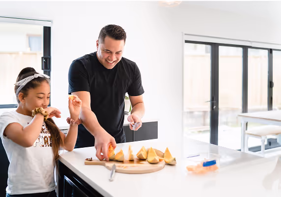 A man and a girl are making food together.