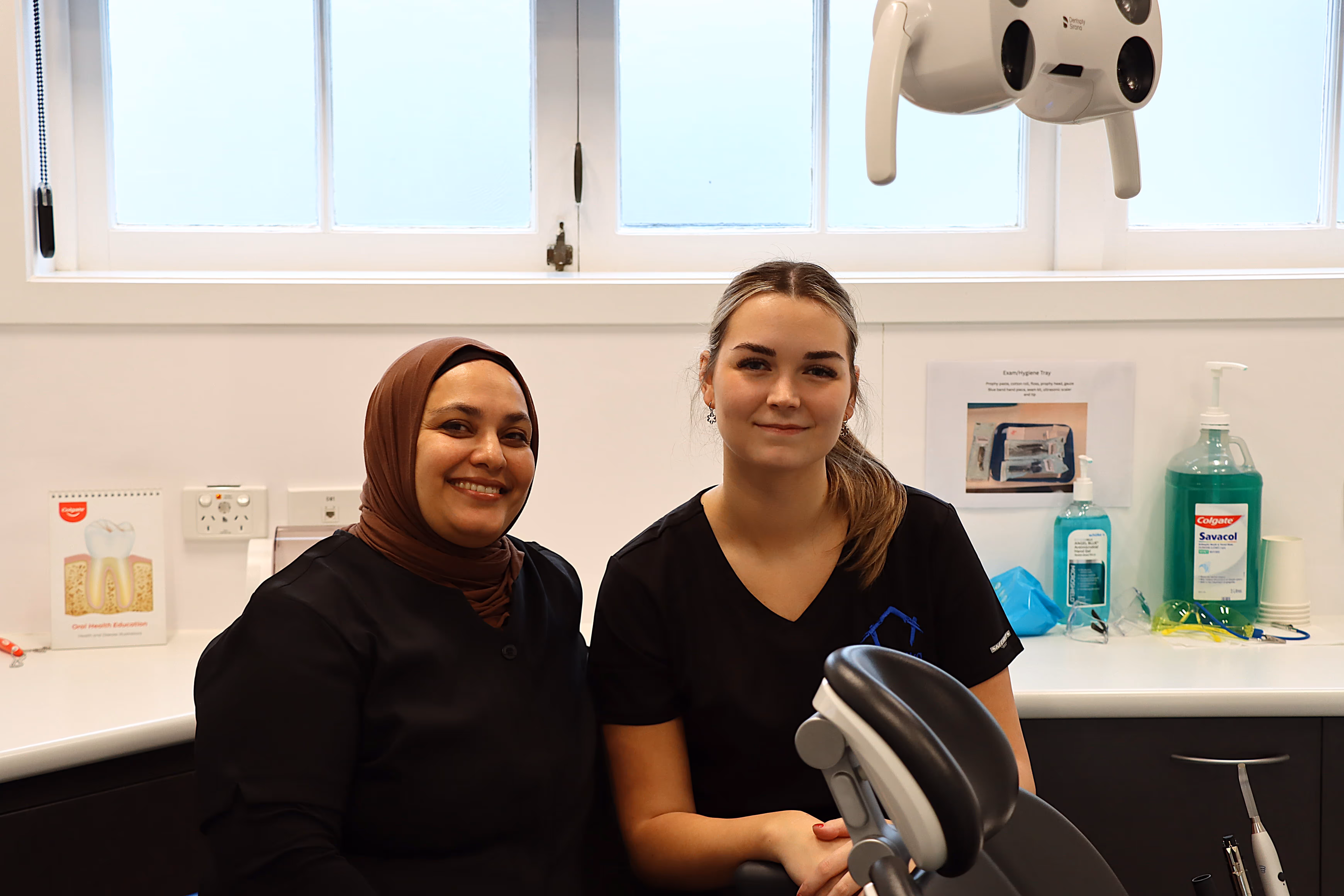 Two women standing in front of a machine.