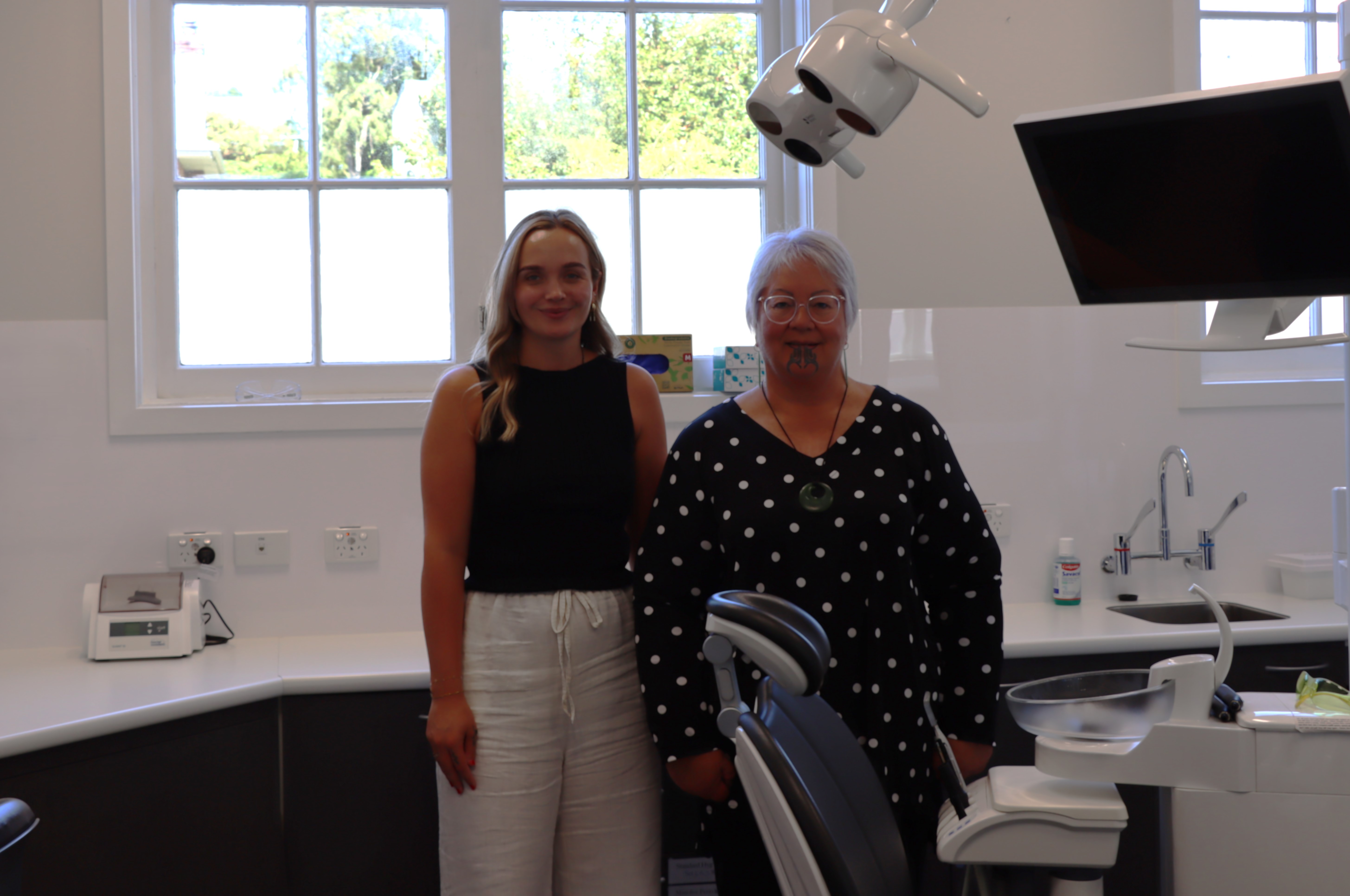 Two women standing in front of a dentist's office.