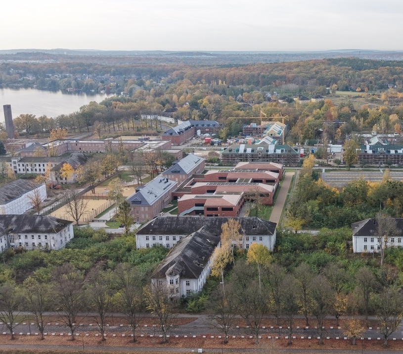 Visualisierung des Aurora Quartett Bauabschnitts 3 mit modernem Wohngebäude, bunt geschmücktem Vorplatz und urbaner Atmosphäre.