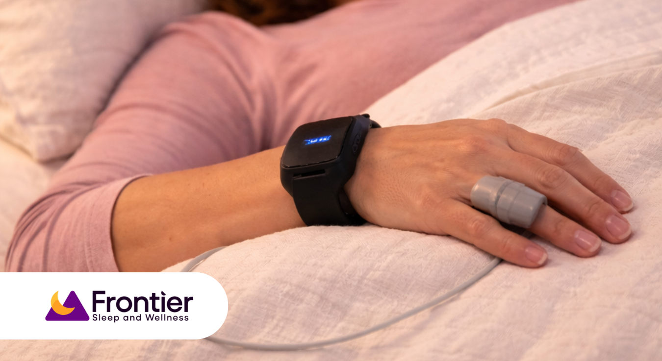 Woman using a home sleep test device while resting in bed, exploring oral appliance cost with insurance and treatment options